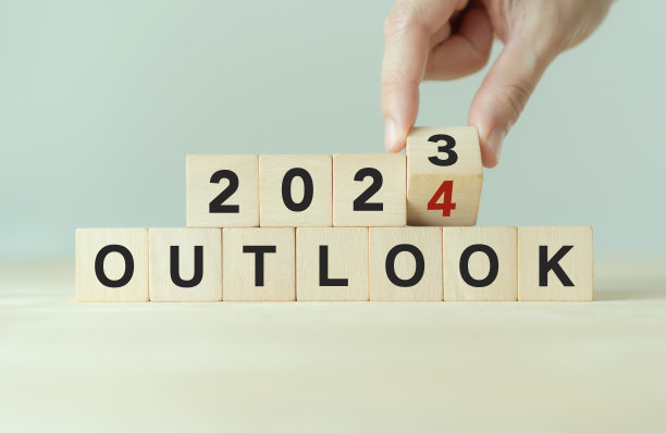 经济展望概念。2024年财务、商业回顾或经济增长预测。将OUTLOOK 2023转换为2024文本在木制立方体块上。图片下载