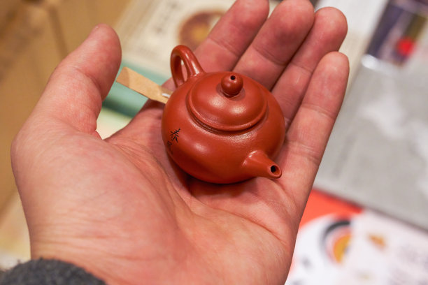 手掌上的中国口袋紫砂茶壶图片下载