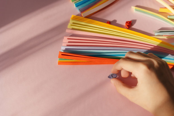 纸和羽毛笔工具在粉红色的背景与手和空间的文字和设计。图片下载