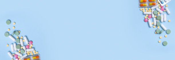蓝色背景上的彩色药丸。保健和医药概念平铺。带有复制空间的横幅图片下载