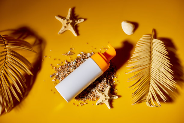 俯视图，平铺防晒霜管模型与贝壳，沙黄色图片下载