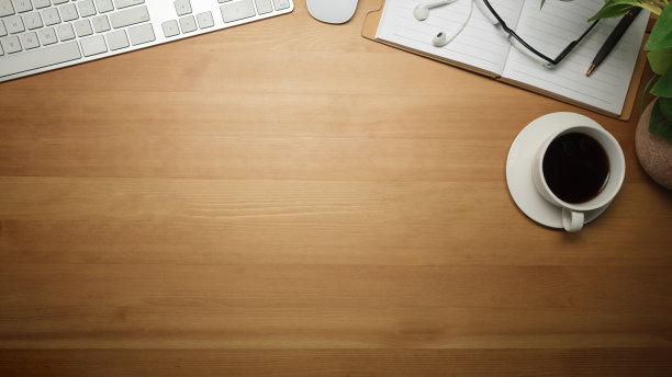 木制办公桌，配有一杯黑咖啡，眼镜，键盘和笔记本。带复制空间的俯视图。图片下载