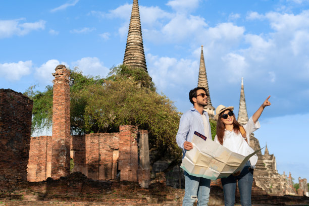 一对年轻夫妇在大城府旅游时使用纸质地图指南图片下载