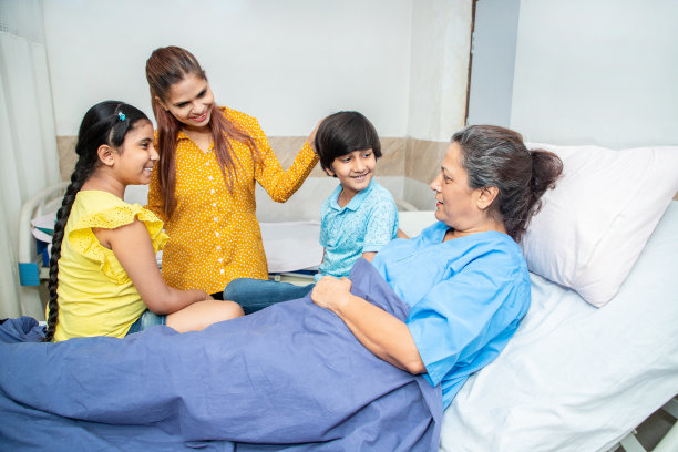 老年女病人躺在医院的床上和她的孙子们说话。家人去诊所见奶奶。老年人保健。图片下载