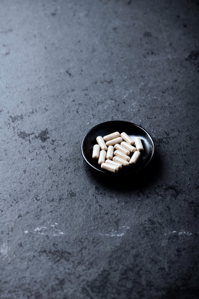 阿什瓦甘达胶囊。暗石背景。软的焦点。关闭了。副本的空间。图片下载
