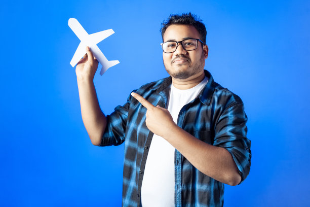 印度年轻人拿着剪纸飞机，用手指着图片下载