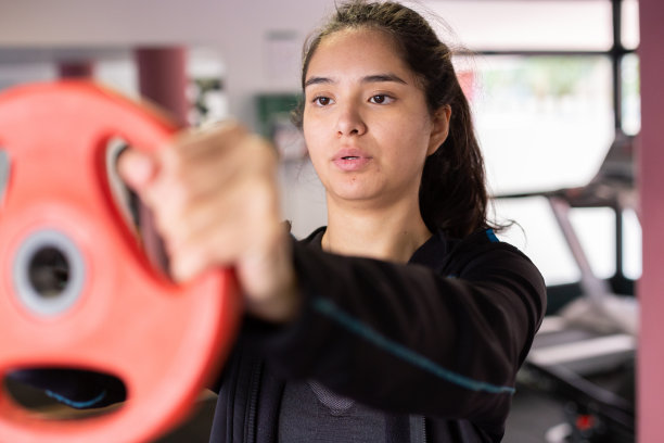 西班牙裔年轻女运动员在健身房举重图片下载
