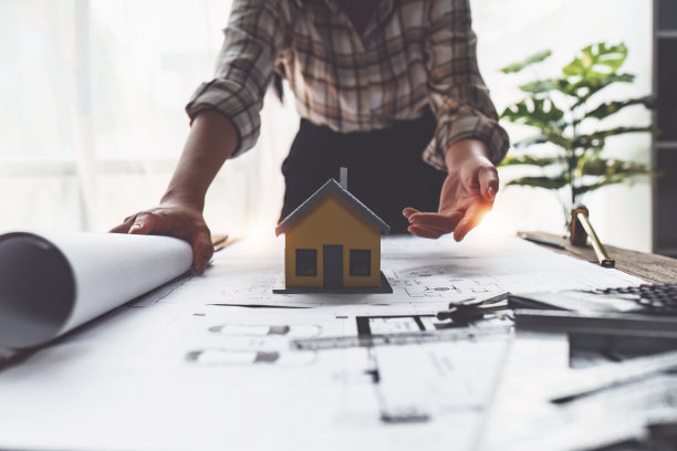 建筑师绘制建筑蓝图，工程师绘制建筑项目草图，绿色能源概念图片下载