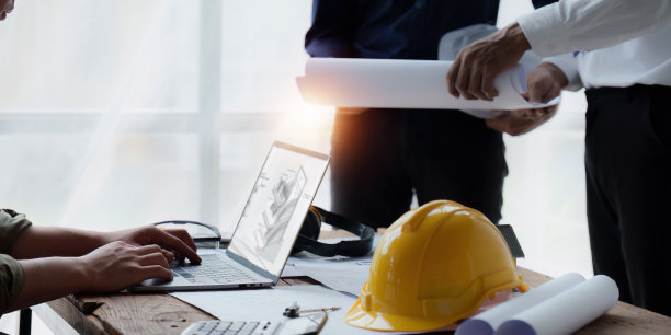 建筑师和工程师为建筑计划绘制蓝图，工程师为建筑项目绘制草图，绿色能源概念图片下载