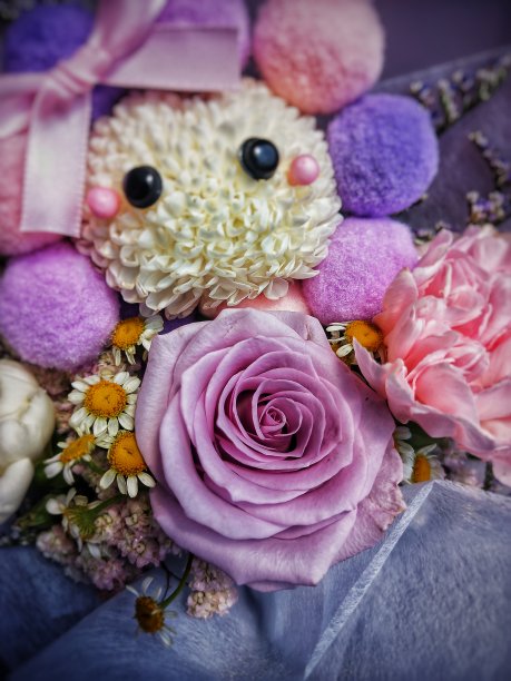 紫色玫瑰的选择性焦点周围的装饰和花束中的其他花卉的模糊背景。图片下载