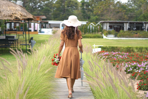 一位亚洲妇女在美丽的花园里散步图片下载