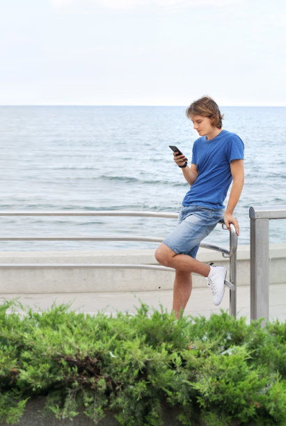 一个年轻人沿着散步道散步并拍照图片下载