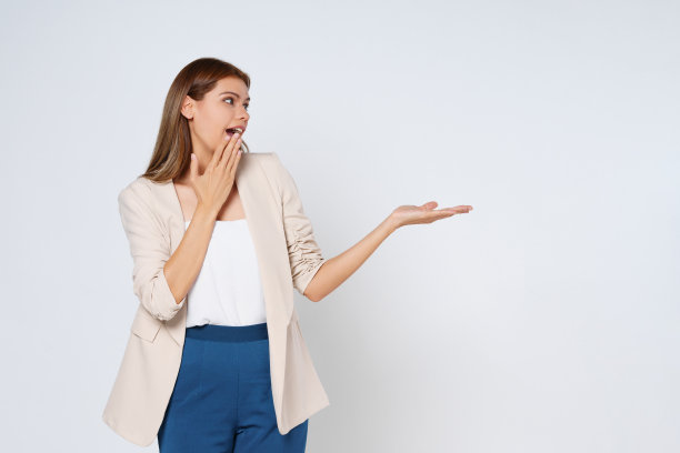 快乐的年轻女子呈现或显示张开的手掌与白色背景的产品的复制空间。图片下载