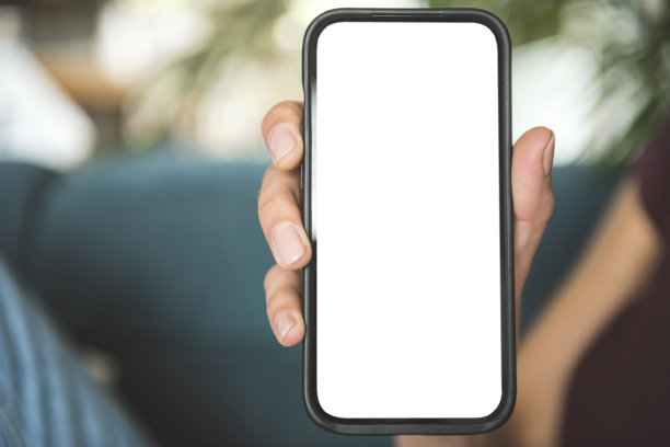 一名女子手持黑色手机，桌面屏幕是空白的图片下载