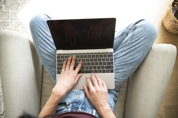 女性在家中手持笔记本电脑的近照图片下载