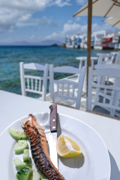 沙滩上的桌子上放着烤章鱼腿。图片下载