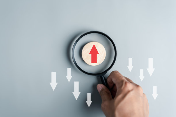 手持式放大镜聚焦于红色箭头和不同方向，与白色箭头面对相反的方向，用于业务中断和技术转型以及不同的思维理念概念。图片下载