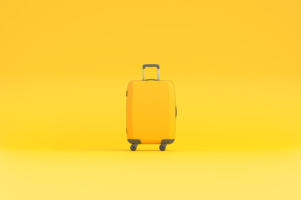 旅行箱的黄色背景与复制空间图片下载