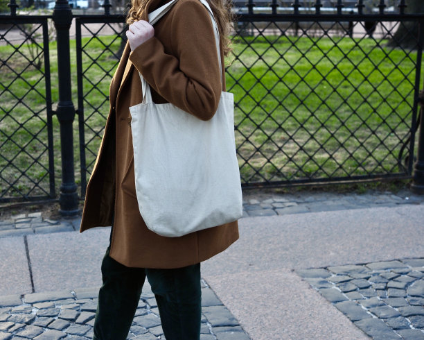 一个漂亮的卷发女孩穿着棕色外套走在欧洲的城市里图片下载