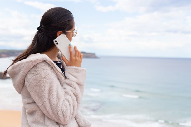 西班牙裔女士拿着智能手机，戴着无线耳机听音乐图片下载