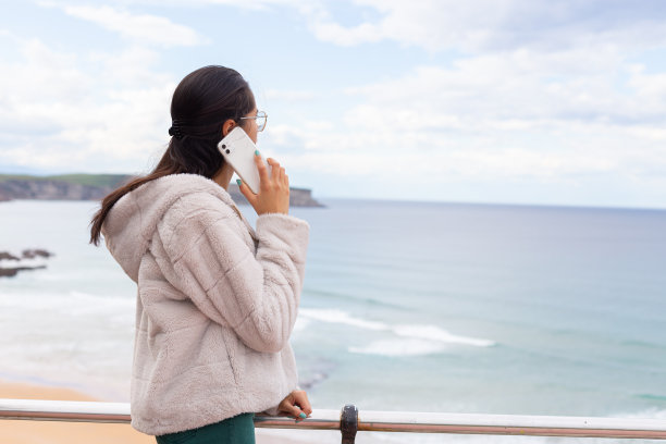 西班牙裔女士拿着智能手机，戴着无线耳机听音乐图片下载