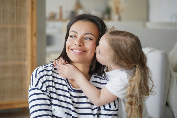 全家福，孩子拥抱妈妈，亲吻妈妈。妈妈在微笑。爱和母性的概念。图片下载
