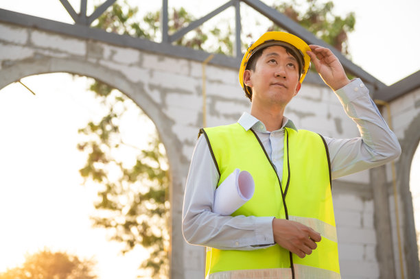 一名亚洲工程师戴着安全帽在工地分析施工图图片下载