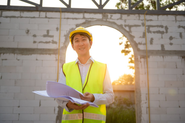 一名亚洲工程师戴着安全帽在工地分析施工图图片下载