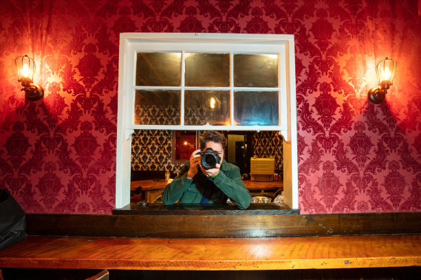 摄影师从窗户探出身子，举着相机图片下载
