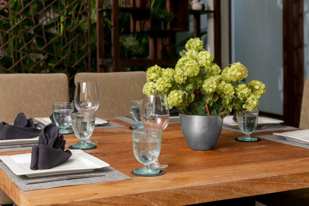 巨大的木制餐桌，阳台上点缀着美丽的花朵图片下载