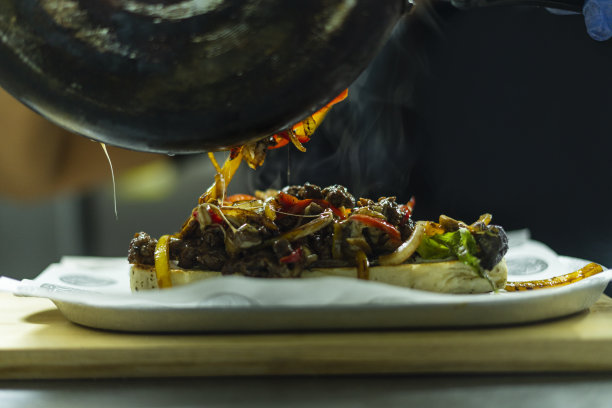 餐厅的厨师正在为准备汉堡包做切料图片下载