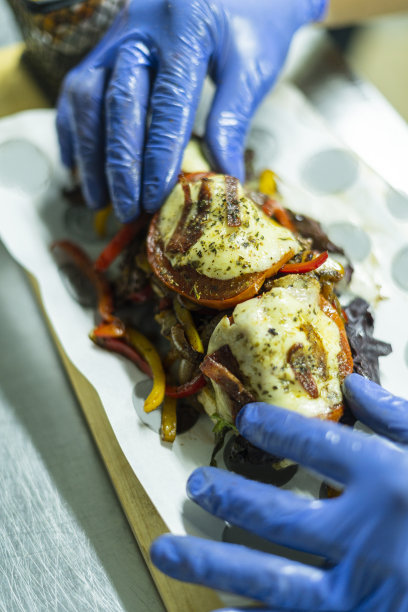 餐厅的厨师正在为准备汉堡包做切料图片下载