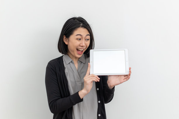 可爱的亚洲年轻女子拿着数码平板电脑图片下载