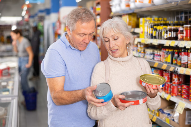 丈夫和妻子一起在超市的食品杂货店挑选罐头食品图片下载