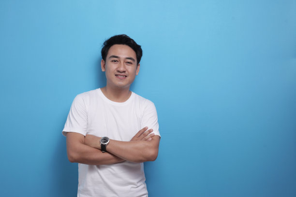 快乐成功自信的亚洲男人双臂交叉站着，对着镜头微笑图片下载