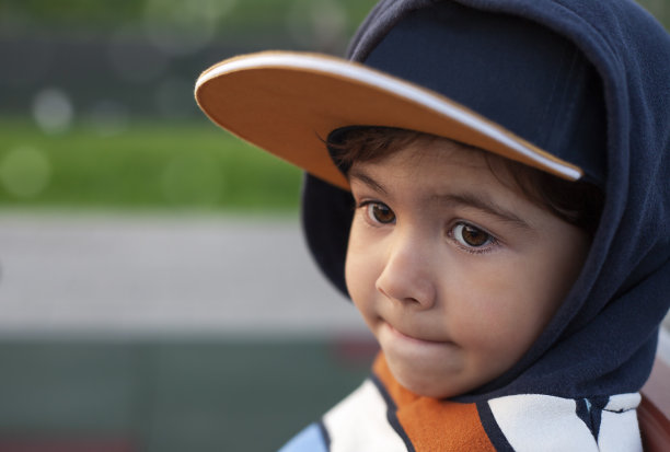一个戴着棒球帽的可爱小男孩的肖像图片下载