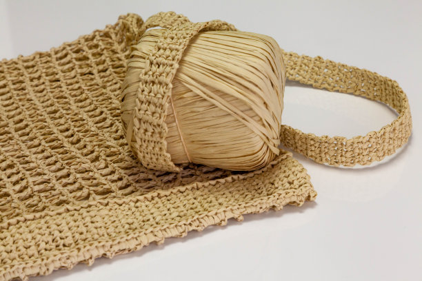 稻草色的线轴放在手工制作的奶奶包上图片下载