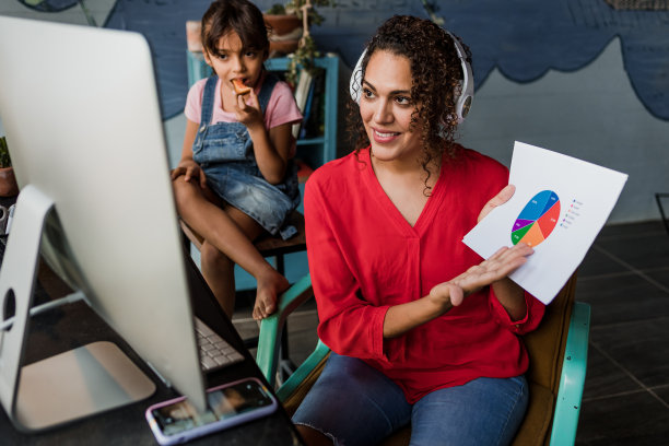 拉丁裔单身母亲一边在家开视频会议一边照顾她在墨西哥的女儿拉丁美洲，家庭办公室概念，拉丁裔女性图片下载