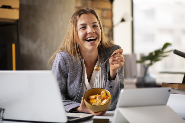 女商人在办公室吃健康零食。图片下载