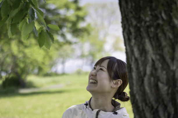 微笑的年轻女子在公园里散步图片下载