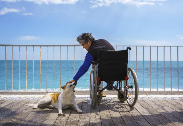 坐在轮椅上的老妇人在沙滩上散步图片下载