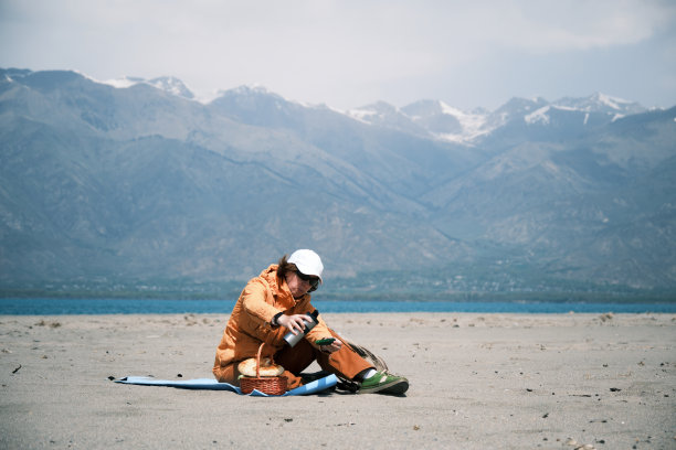 一位背包客正在山间的湖边野餐图片下载