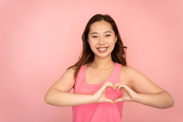 在摄影棚里，微笑的女人用她的双手做着亲切的手势。图片下载