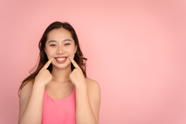 美丽的年轻女子微笑时露出脸颊上的酒窝。图片下载