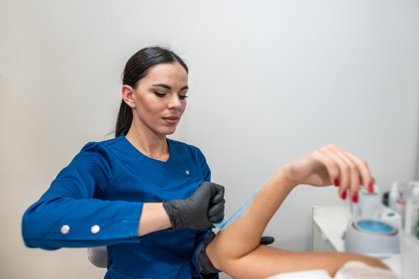 美容师将蜡膏凝胶涂抹在女性客户的手上图片下载