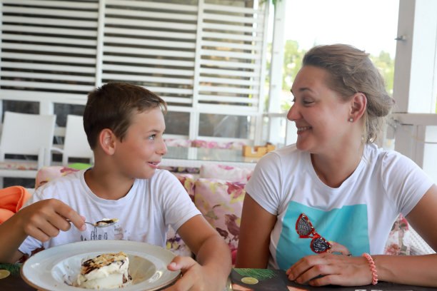 母亲和儿子在餐厅的露台上吃午饭图片下载