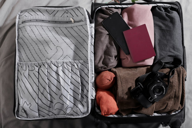 床上装有数码相机和护照的小手提箱的俯视图图片下载