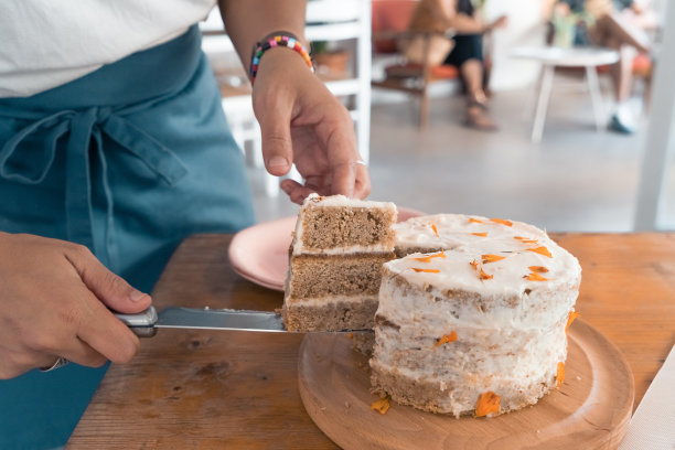 服务员正在切美味的自制胡萝卜蛋糕图片下载