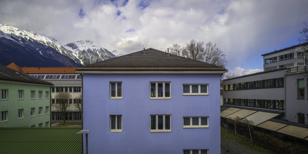 阿尔卑斯山北部山脉景观，白雪覆盖的山峰天际线和云景在奥地利西部村庄的屋顶和建筑物，火车旅行风景照片图片下载