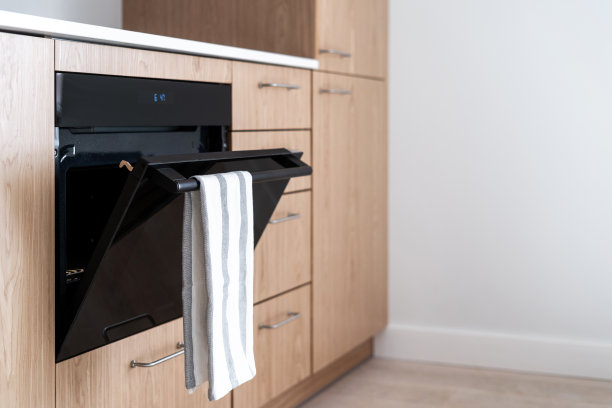 厨房毛巾挂在打开的烤箱门把手上图片下载